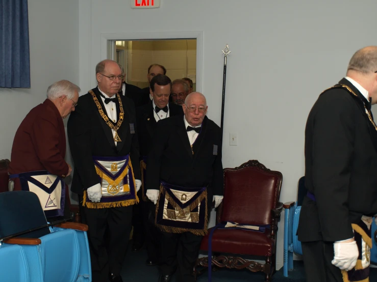 men in black jackets and ties standing next to each other