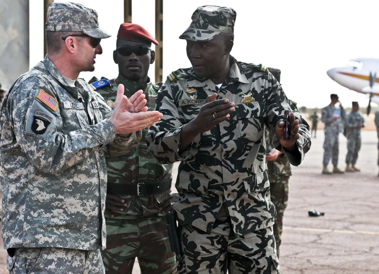two men in military uniforms talking to other men