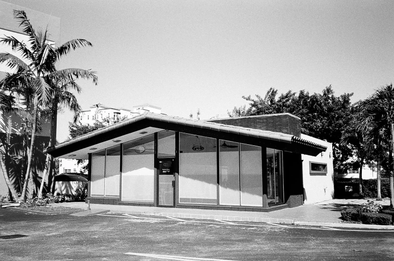 an old bus stop sitting next to palm trees