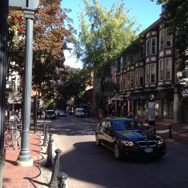 cars and buildings along a street with pedestrians