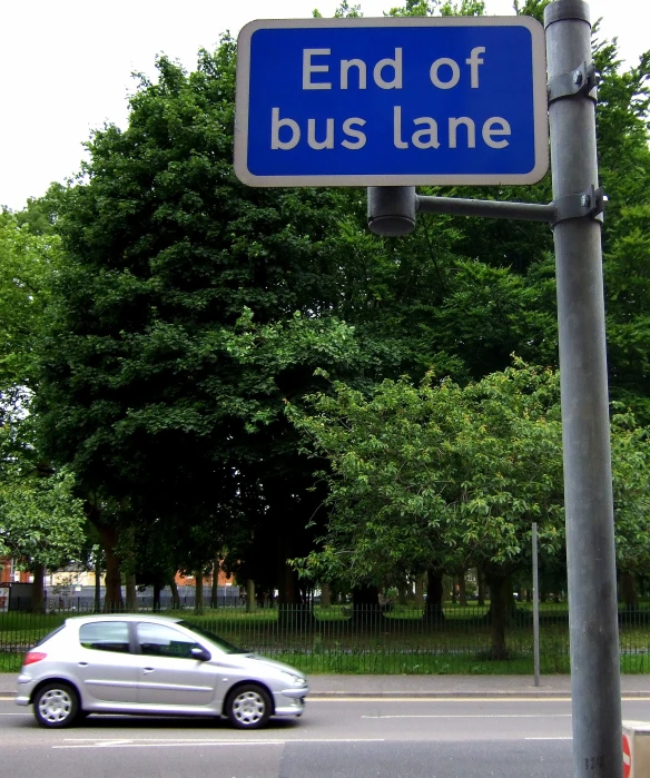 blue sign saying end of bus lane with cars in front