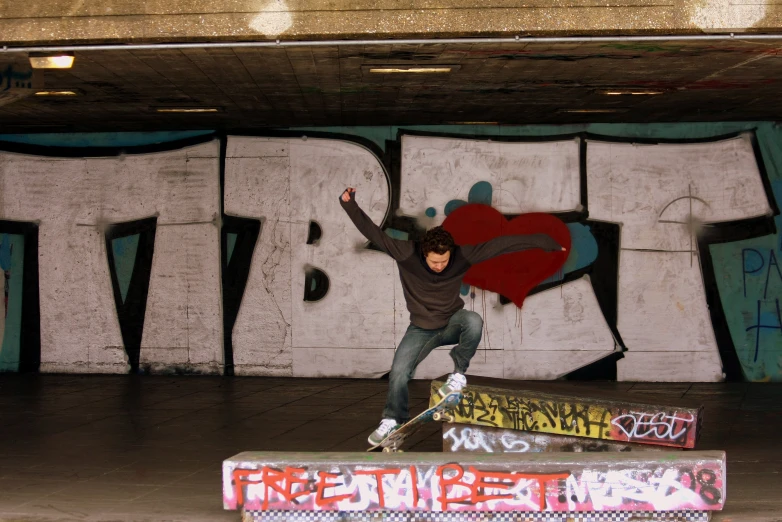 there is a boy doing skateboard tricks in a graffiti covered tunnel