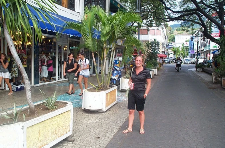 people walk by shops down the street in an asian country