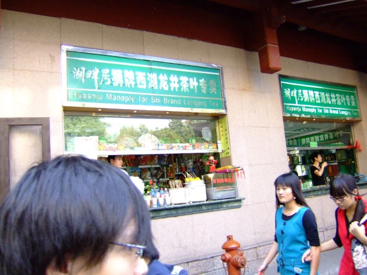 two young women stand near the shop in china