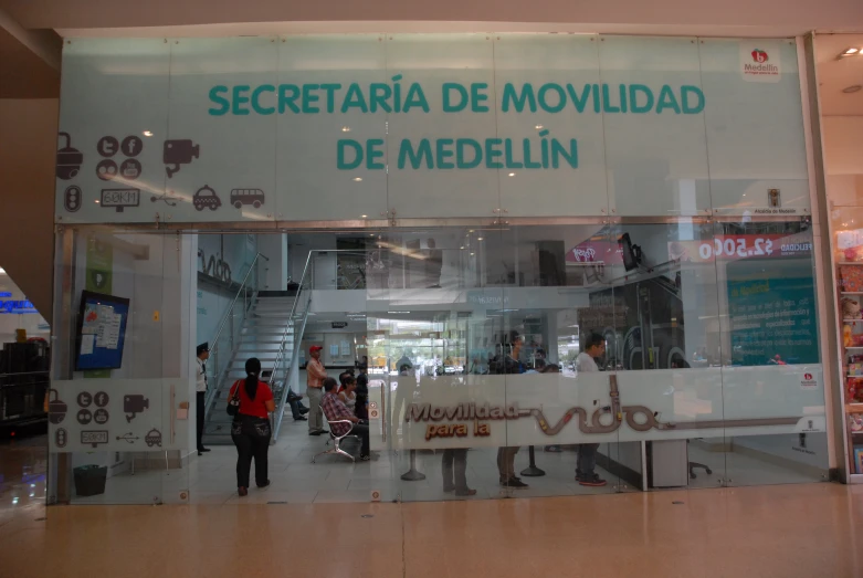 an indoor mall with a large sign showing people shopping in it