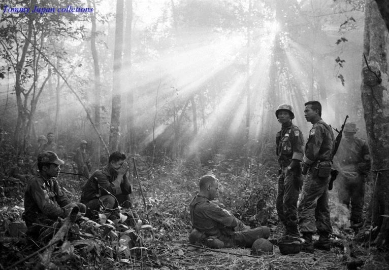 men in the woods with weapons and a man in a vest