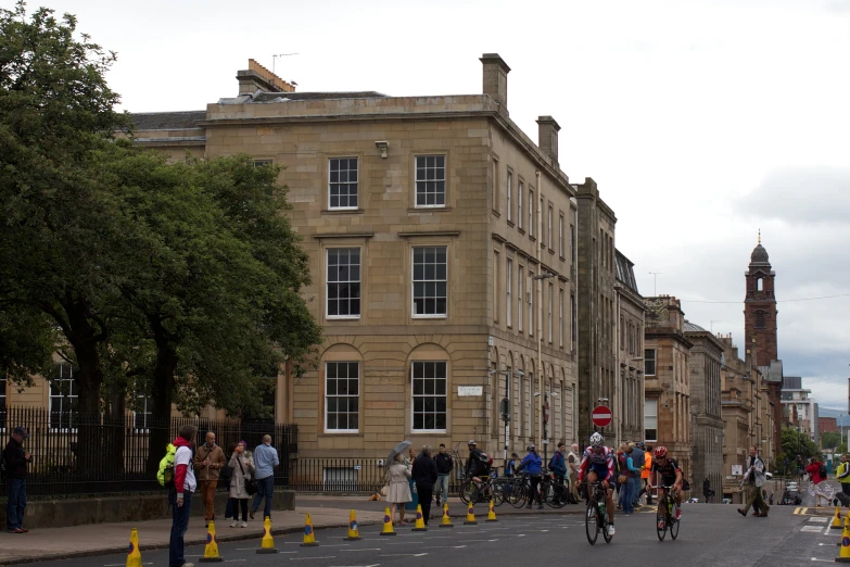 cyclists pass through a crosswalk and yellow cones