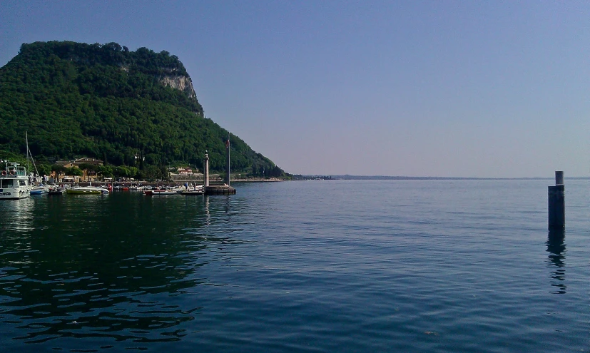 many boats are docked in the harbor by the shore