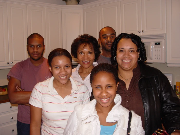 a group of people standing together in the kitchen