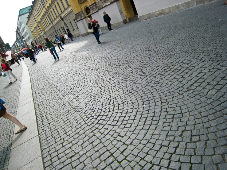 a couple of people standing on a cobblestone street