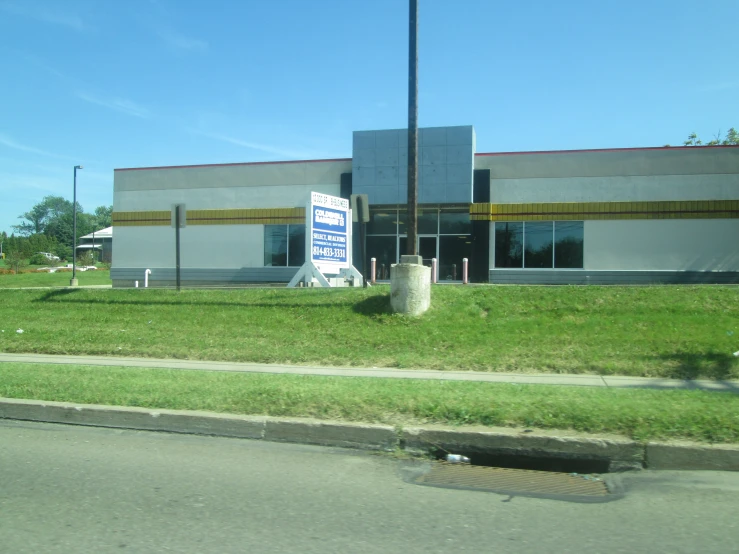 a sign is on the grass in front of a building