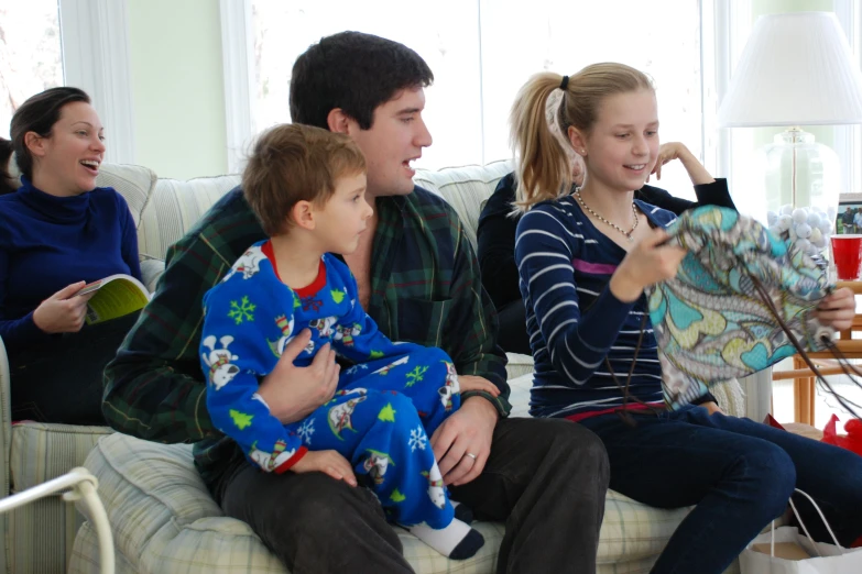 three people in pajamas sitting on a couch