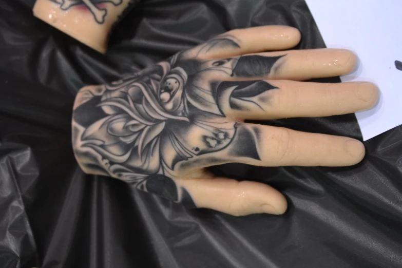 a man wearing a skull hand tattoo with a rose on it