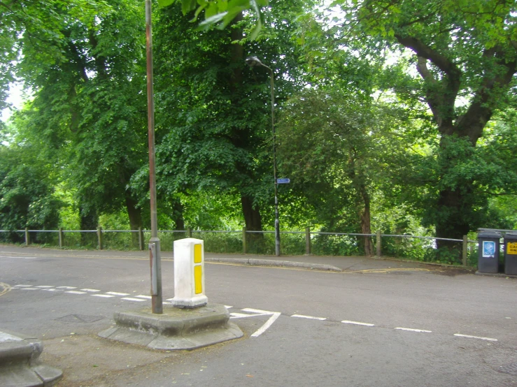 there is a cement curb next to a road with trees