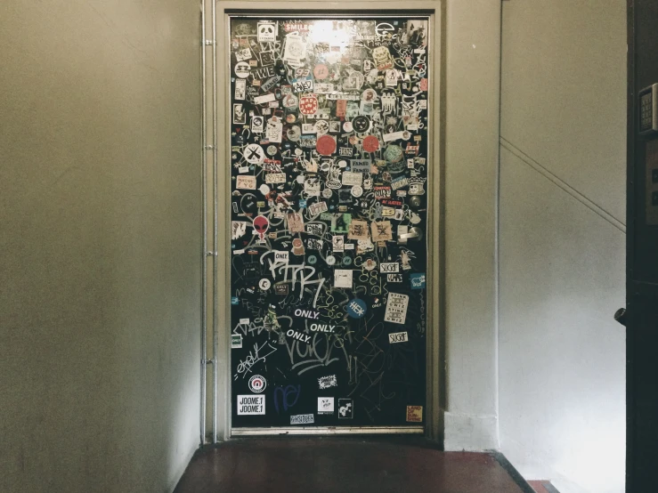 a doorway to an elevator with various images on it