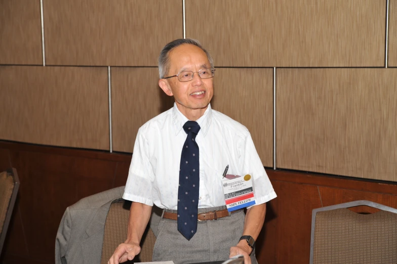 an old man wearing a uniform holding a tablet