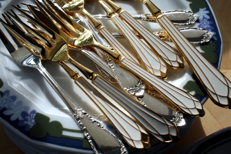 gold - plated forks and knives on an intricately decorated plate