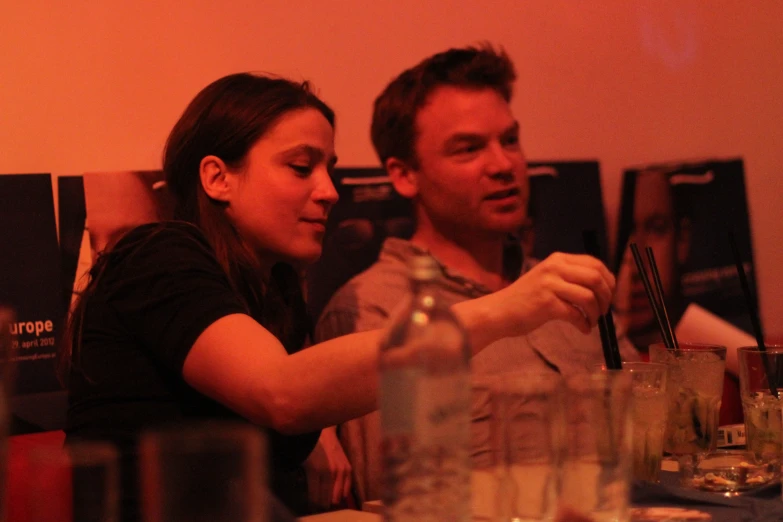 two people sitting at a dinner table sharing a drink