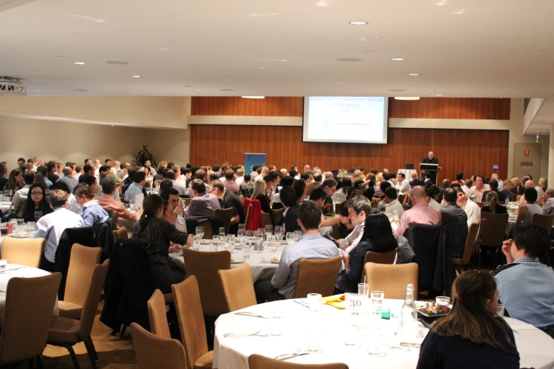 a crowd of people is gathered inside a ballroom