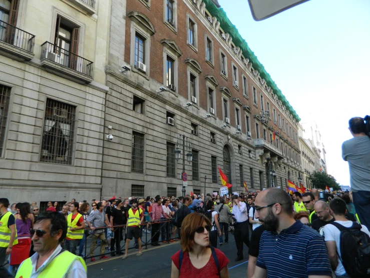 a group of people march in the street near buildings