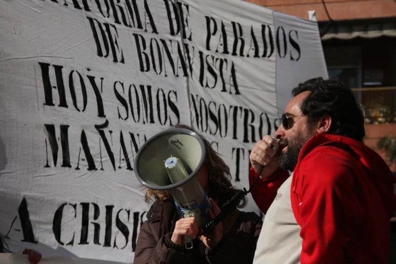 a protester holding a bull horn and microphone during a demonstration