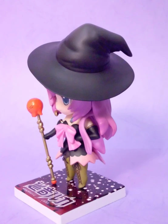 an anime figure in a black hat and long dress