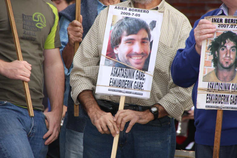 people holding protest signs and posters while looking towards camera