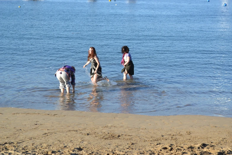 children in the water, playing with two dogs