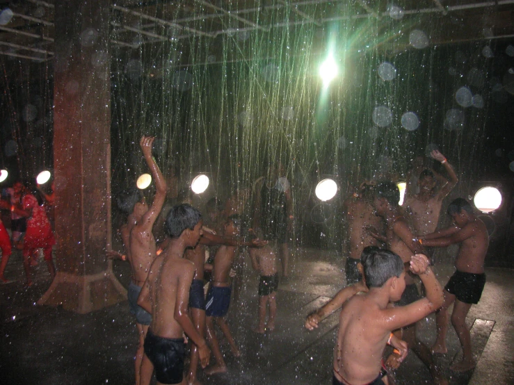 several people playing with a fountain in the rain