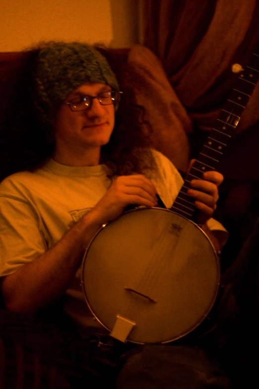 a man sitting with a hat on his head playing a large instrument