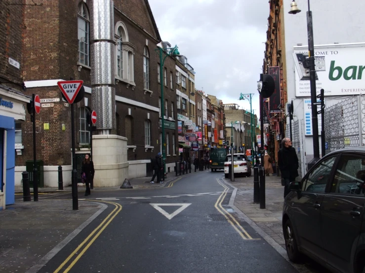 a narrow street is surrounded by brick buildings and other business