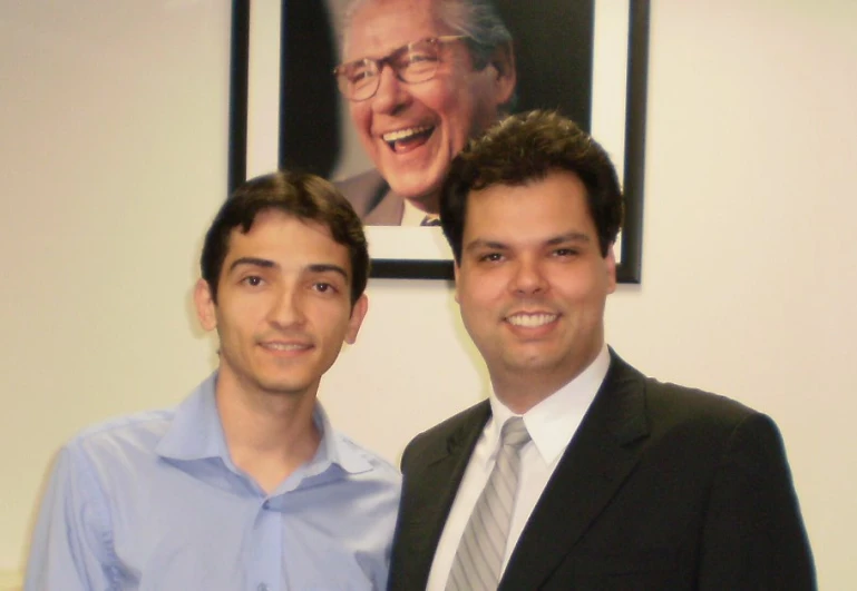 two men are posing for a po in front of a portrait of president ronald castro