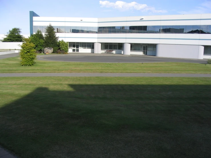 a large building with several windows and grass