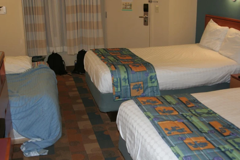 two beds are next to each other in a motel