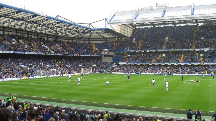 a stadium filled with lots of people standing on top of a soccer field