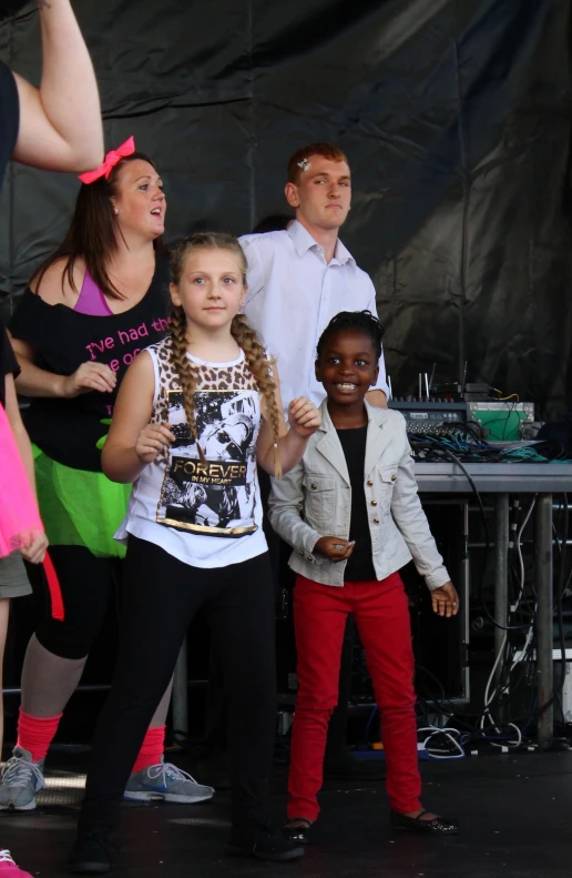 a group of children stand at a music stage
