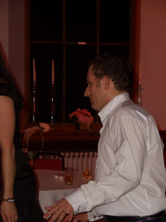 a man and woman standing in the room next to each other