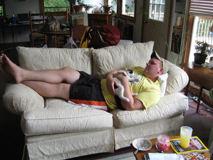 a man is lying on a couch playing a video game