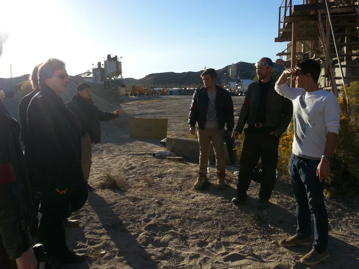 a group of men are gathered in a barren area