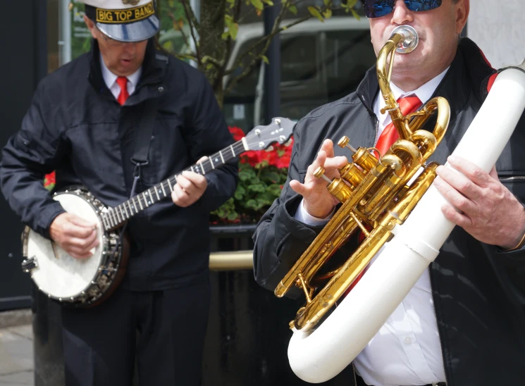 man playing ss instrument while two men watch