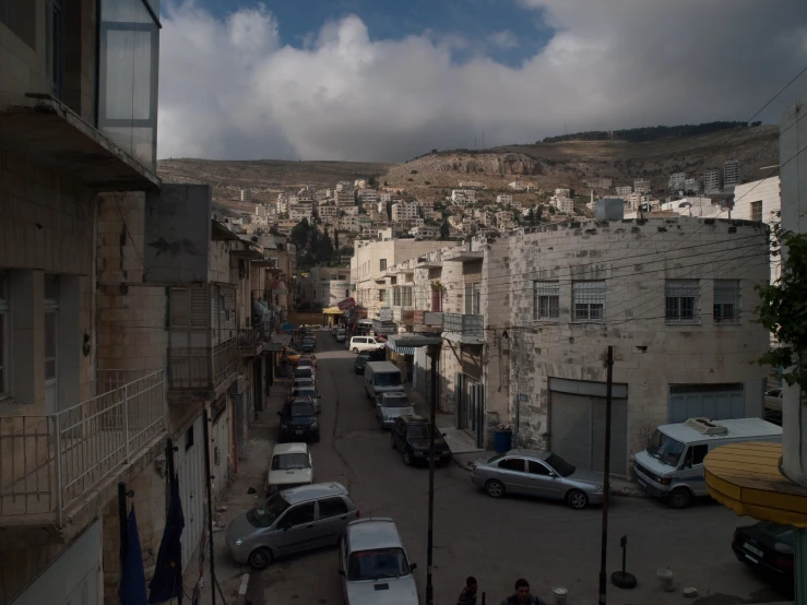 a view of an old town with lots of cars parked on the side of it