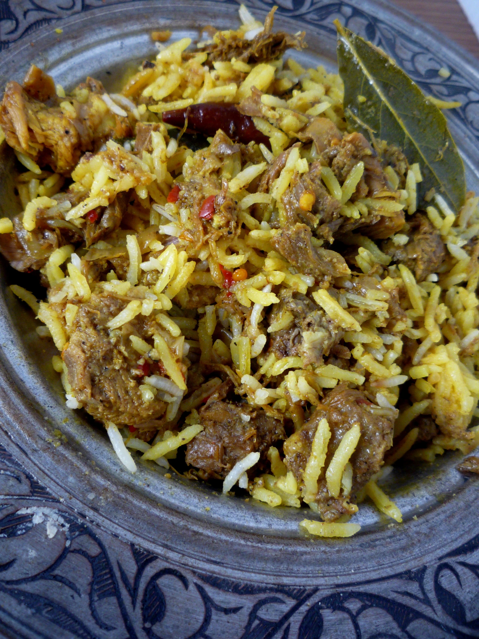 a bowl filled with meat and rice sits on a blue table cloth