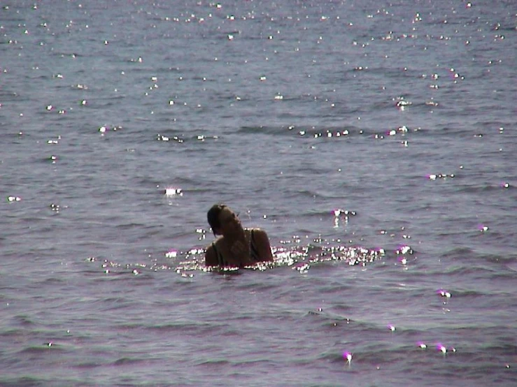 a person is floating in the water, with a surfboard