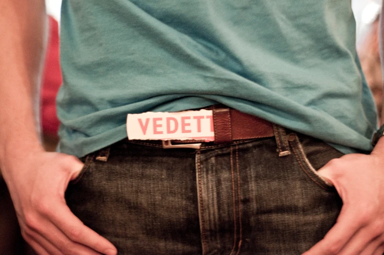 a man with jeans and a belt with a badge on it