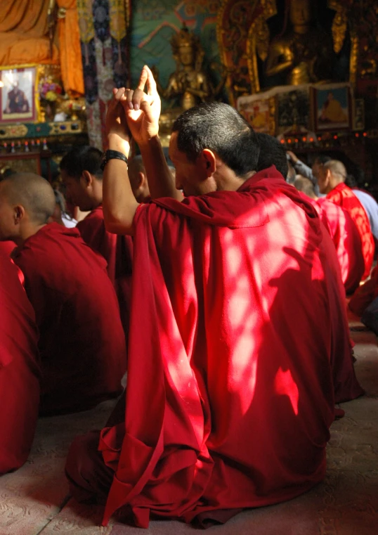 several monks sitting on the floor while practicing yoga