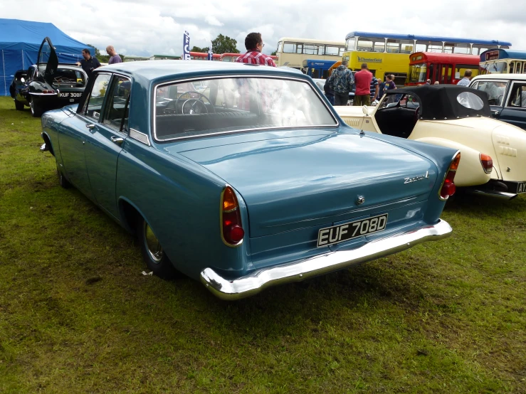 many classic cars are parked in the grass