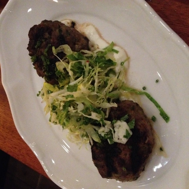 two small meat patties sitting on top of a plate on a table