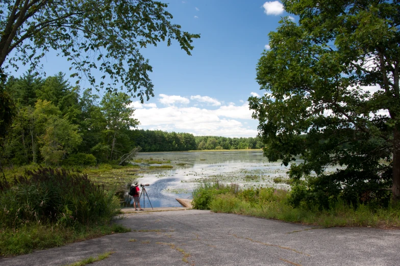 there is a man sitting by the lake by himself