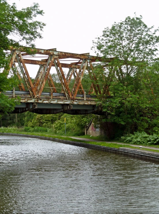 a large bridge over a river next to trees