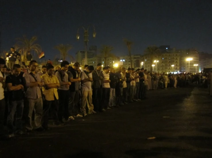 a crowd of people stand around and listen to someone speak